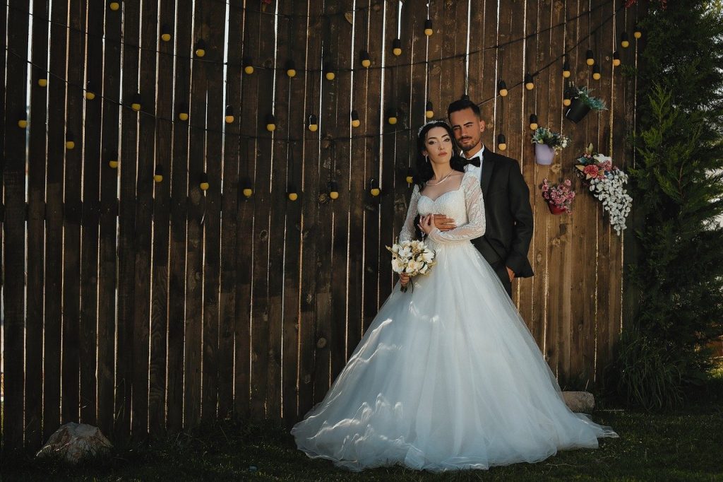 In einem festlich dekorierten Raum diskutieren eine Braut und ein Bräutigam mit ihrem Weddingplaner die letzten Details für ihre Traumhochzeit.