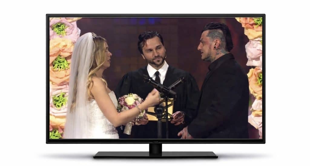 Fernseher zeigt DSDS Hochzeit mit Brautpaar und Trauredner Samuel Diekmann auf der Bühne.