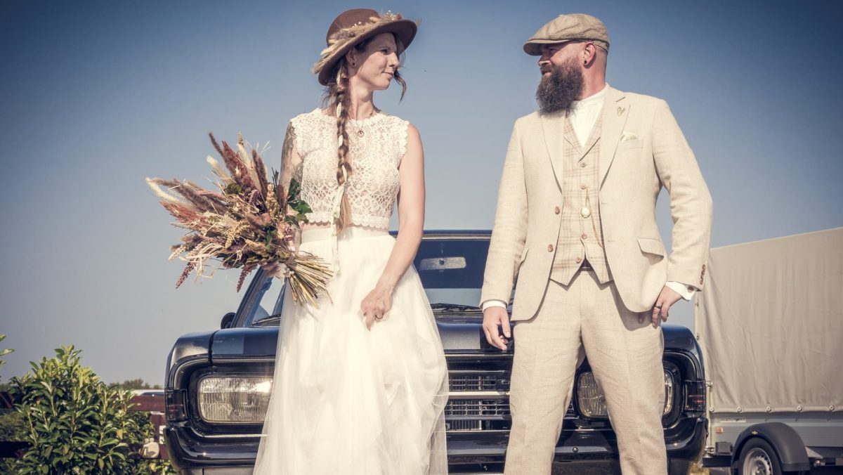 Brautpaar bei einer freien Trauung im Kreis Offenbach im Rhein-Main-Gebiet steht vor einem Oldtimer und schaut sich an